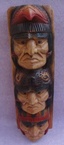 Un poteau en bois avec des têtes des indiens